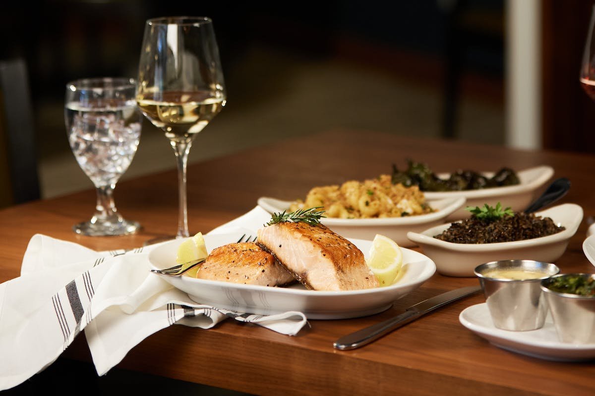 a plate of food and glasses of wine on a table